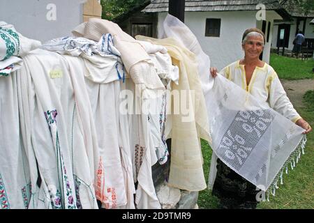 Contea di Brasov, Romania. Donna che vende camicie e veli rumeni tradizionali fatti a mano. Foto Stock