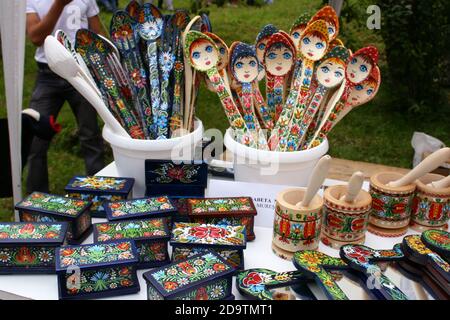 Artigianato tradizionale in legno intagliato a mano e dipinto a mano per la vendita in una fiera di campagna nella contea di Brasov, Romania Foto Stock