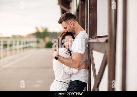 felice giovane uomo e donna che si diverte all'aperto in una calda giornata estiva. coppia è abbracciando vicino a cavallo rancho Foto Stock