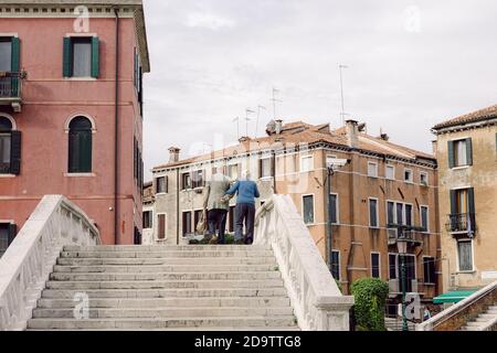 Vecchia coppia a piedi vicino su un ponte a Venezia Foto Stock