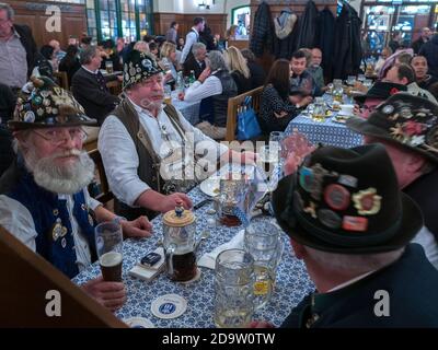 Gli uomini bavaresi locali si uniscono ai turisti al bar Hofbrahaus di Monaco. Foto Stock