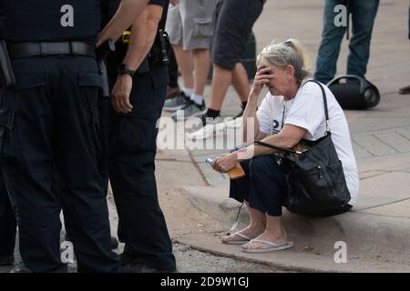 Austin, Texas, Stati Uniti. 07 novembre 2020. Una donna si siede sul marciapiede al Campidoglio del Texas, mentre i gruppi che celebrano la vittoria elettorale di Joe Biden si affrontano con i sostenitori pro-Trump al Campidoglio del Texas. La polizia di Austin e i soldati del Texas hanno cercato di tenere separati i due gruppi. La protesta è stata numerata poche centinaia dopo che Biden è stato dichiarato vincitore per il presidente degli Stati Uniti il 7 novembre 2020. Credit: Bob Daemmrich/Alamy Live News Credit: Bob Daemmrich/Alamy Live News Foto Stock