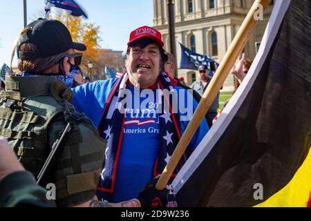 Lansing, Michigan USA - 7 novembre 2020 - UN piccolo gruppo di attivisti della materia Black Lives si è confrontato con i sostenitori del presidente Trump che protestavano per l'esito delle elezioni al campidoglio del Michigan. Nonostante gli individui di entrambe le parti portassero armi da fuoco, gli scambi tra le due parti erano solo verbali. I sostenitori di Trump hanno sostenuto che le elezioni erano state rubate. Credit: Jim West/Alamy Live News Foto Stock