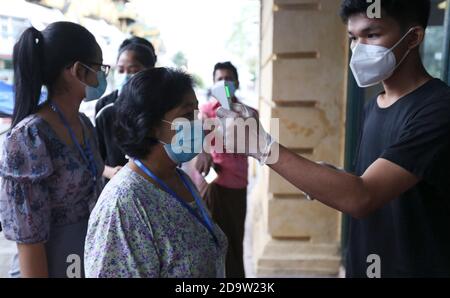 Yangon, Myanmar. 8 Nov 2020. Gli elettori ottengono la loro temperatura controllata prima di entrare in una stazione di polling a Yangon, Myanmar, 8 novembre 2020. Domenica il Myanmar ha dato il via alle elezioni generali multipartitiche, mentre oltre 37 milioni di elettori hanno partecipato ai sondaggi in tutto il paese. Credit: U Aung/Xinhua/Alamy Live News Credit: Xinhua/Alamy Live News Foto Stock