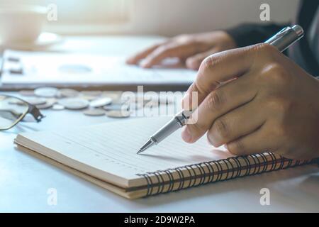 Mano dell'uomo, firma, compilazione di documenti o presa di appunti su documenti finanziari. Foto Stock