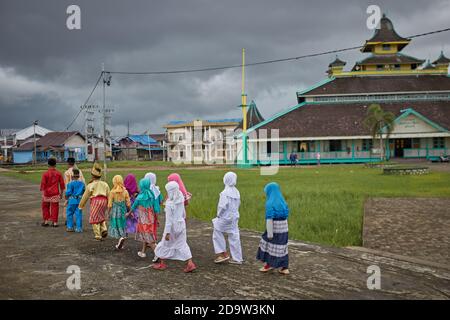 Pontianak, Kalimantan, Indonesia, febbraio 2016. I bambini passano davanti alla Moschea del Sultano Syarif Abdurrahman. Foto Stock