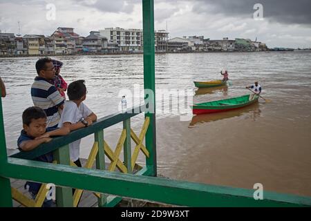 Pontianak, Kalimantan, Indonesia, febbraio 2016. Una famiglia attende il traghetto per attraversare il fiume. Foto Stock