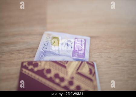 20 banconota da Corona svedese parzialmente all'interno di un passaporto svedese Foto Stock