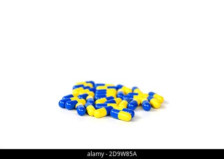 Gruppo di closeup della capsula gialla e blu medicinale su sfondo bianco. Foto Stock