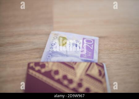 20 banconota da Corona svedese parzialmente all'interno di un passaporto svedese Foto Stock