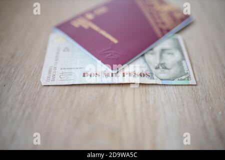 Duemila pesos Bill colombiani in parte all'interno di un passaporto svedese Foto Stock