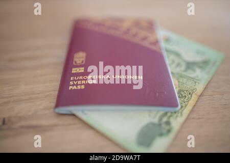 Svezia Passport con un blurry venti Thai Baht Bill parzialmente Interno Foto Stock