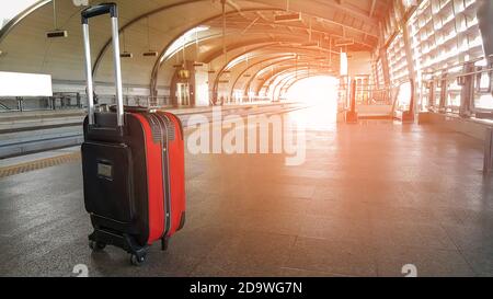 I bagagli del trolley sono appoggiati sul pavimento della stazione ferroviaria, concetto di trasporto, viaggio e turismo. Foto Stock