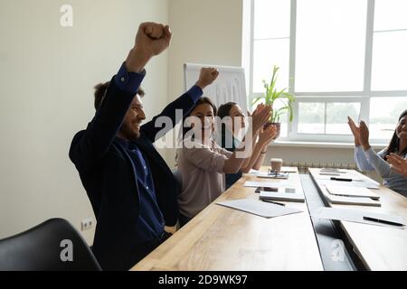 Il team è stato molto felice di aver appigliato le mani, congratulandosi con un collega felice con la promozione Foto Stock