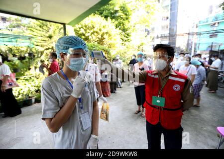 (201108) -- YANGON, 8 novembre 2020 (Xinhua) -- UN elettore ottiene la sua temperatura controllata prima di entrare in una stazione di polling a Yangon, Myanmar, 8 novembre 2020. Domenica il Myanmar ha dato il via alle elezioni generali multipartitiche, mentre oltre 37 milioni di elettori hanno partecipato ai sondaggi in tutto il paese. Credit: Xinhua/Alamy Live News Foto Stock