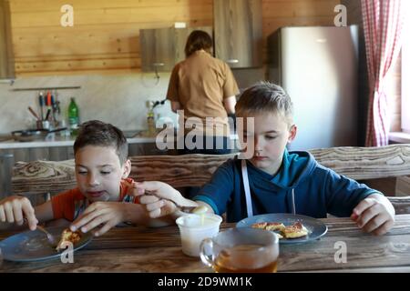 I bambini mangiano a casa pancake con latte condensato Foto Stock