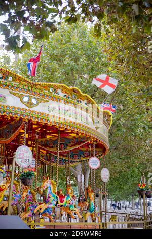 Ritratto Vista di un bambino Carouser colorato circondato da Alberi di un parco Foto Stock