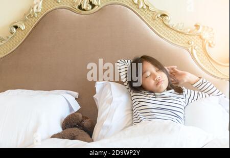 Bambina a letto. Il bambino a casa si sveglia a letto al mattino Foto stock  - Alamy