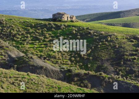 Scena abbandonata agricoltura in Sicilia con rovine di case coloniche in pietra Foto Stock