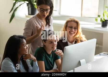 Una donna biraciale sicura che controlla il lavoro di squadra sul progetto Foto Stock