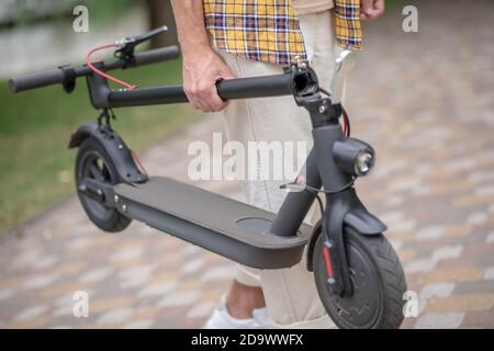 Scooter. Uomo in camicia a scacchi con il suo scooter Foto Stock