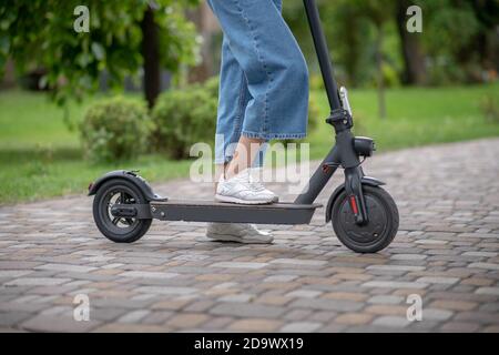 Su uno scooter. Primo piano immagine di gambe umane e scooter Foto Stock