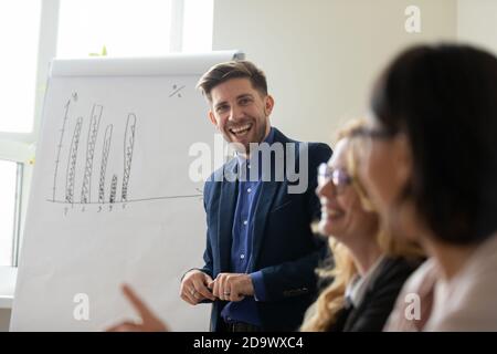 Sorridente allenatore millenario incoraggiando il tirocinante per una buona idea Foto Stock