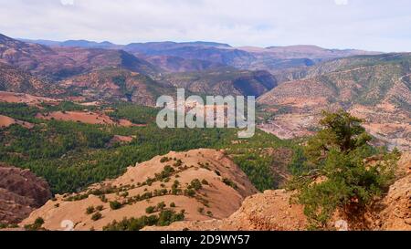 Vista panoramica delle colline ai piedi dei Monti Altas ricoperti di foreste di conifere dalla formazione rocciosa di picco cathedrale imsfrane vicino Tilouguite. Foto Stock