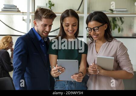 Un gruppo eterogeneo di colleghi che hanno una conversazione in ufficio Foto Stock