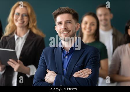 Leader moderno e capace di cordialità e team diversificato in posa per il ritratto Foto Stock