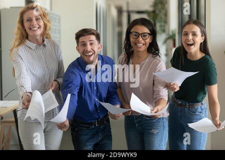 Ritratto di gruppo di ridere entusiasta business team mostrando il contratto confermato Foto Stock