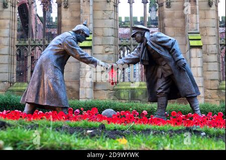 Liverpool, Regno Unito. 8 Nov 2020. Il giardino di papavero del giorno della memoria alla chiesa 'bombed out' di St Luke in Leece Street Liverpool, davanti alla statua chiamata 'All Together Now' progettata da Andy Edwards, cattura il momento in cui i soldati britannici e tedeschi hanno smesso di combattere e giocato a calcio il giorno di Natale 1914. Credit: ken biggs/Alamy Live News Foto Stock