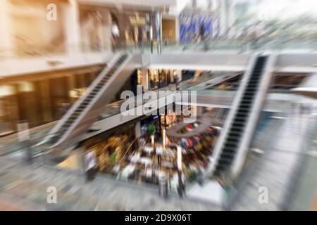 L'astratto offuscava le persone all'interno del centro commerciale; filtra effetto zoom di sfocatura radiale. Foto Stock