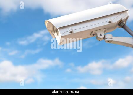 CCTV o telecamera di sorveglianza che registra eventi importanti e una casa di guardia e proprietà contro il cielo blu. Foto Stock