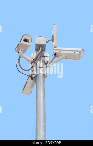 Gruppo di telecamere di sicurezza (CCTV) o telecamera di sorveglianza su palo isolato su sfondo blu. Foto Stock