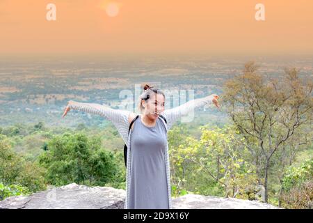 Donne asiatiche in piedi pose, braccia distese sulla cima della montagna. Foto Stock