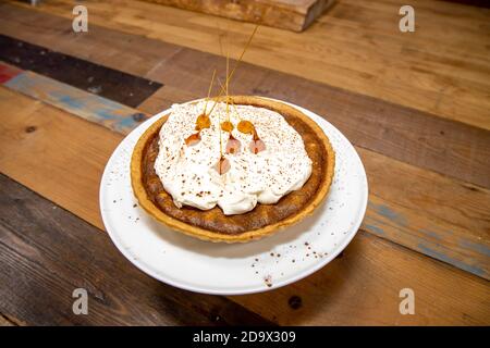 Una deliziosa torta del deserto di una Toffee Bonfire e nocciola crostata su un piano di lavoro di cucina in legno Foto Stock