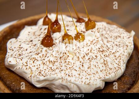 Una deliziosa torta del deserto di una Toffee Bonfire e nocciola crostata su un piano di lavoro di cucina in legno Foto Stock