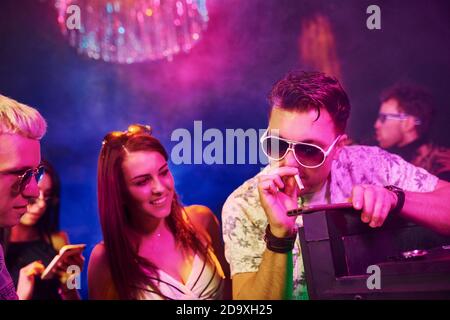 I giovani sniffing la droga in nightclub con le luci laser colorate Foto Stock