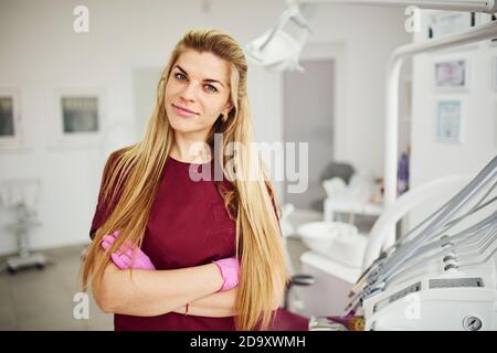 Giovane dentista femminile in piedi uniforme in ufficio di stomatologia Foto Stock