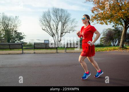 Southend on Sea, Essex, Regno Unito. 8 Nov 2020. I runner hanno partecipato a una corsa a Southend on Sea on Remembrance Domenica per raccogliere fondi per la Royal British Legion, fondi molto necessari a causa della perdita di milioni di sterline di reddito dalla perdita di vendite di papavero attraverso il blocco COVID 19. I runner della mattina presto hanno goduto di una mattina d'autunno brillante e croccante. Guida femmina Foto Stock