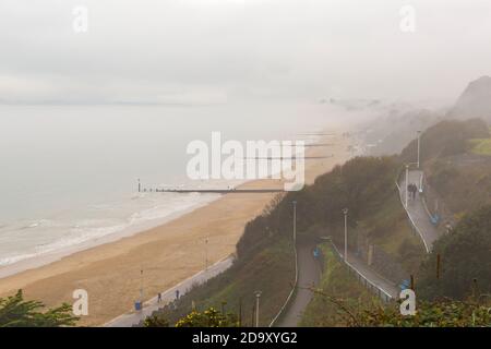 Bournemouth, Dorset UK. 8 novembre 2020. Tempo in Gran Bretagna: Grigio murky giorno piovoso come la bassa nebbia abbracca le scogliere sopra la spiaggia con le cime delle scogliere che scendono lungo la costa a Bournemouth. Oggi non molte persone sulle spiagge rispetto a ieri. Credit: Carolyn Jenkins/Alamy Live News Foto Stock