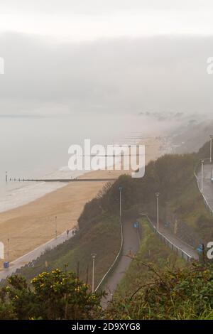 Bournemouth, Dorset UK. 8 novembre 2020. Tempo in Gran Bretagna: Grigio murky giorno piovoso come la bassa nebbia abbracca le scogliere sopra la spiaggia con le cime delle scogliere che scendono lungo la costa a Bournemouth. Oggi non molte persone sulle spiagge rispetto a ieri. Credit: Carolyn Jenkins/Alamy Live News Foto Stock