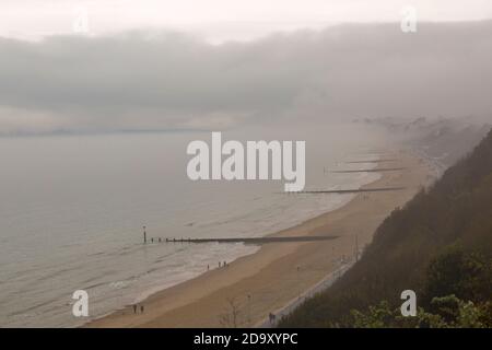 Bournemouth, Dorset UK. 8 novembre 2020. Tempo in Gran Bretagna: Grigio murky giorno piovoso come la bassa nebbia abbracca le scogliere sopra la spiaggia con le cime delle scogliere che scendono lungo la costa a Bournemouth. Oggi non molte persone sulle spiagge rispetto a ieri. Credit: Carolyn Jenkins/Alamy Live News Foto Stock