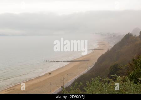 Bournemouth, Dorset UK. 8 novembre 2020. Tempo in Gran Bretagna: Grigio murky giorno piovoso come la bassa nebbia abbracca le scogliere sopra la spiaggia con le cime delle scogliere che scendono lungo la costa a Bournemouth. Oggi non molte persone sulle spiagge rispetto a ieri. Credit: Carolyn Jenkins/Alamy Live News Foto Stock