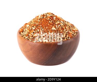 Mescolare erbe, spezie e pomodori secchi in una ciotola di legno, isolata su sfondo bianco. Condimento naturale di cibo biologico. Foto Stock