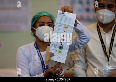 Yangon, Myanmar. 8 Nov 2020. Un funzionario della commissione elettorale dell'Unione presenta uno scrutinio per il conteggio dei voti durante le elezioni generali multipartitiche in un seggio elettorale a Yangon, Myanmar, 8 novembre 2020. Domenica pomeriggio il Myanmar ha concluso con successo il voto delle elezioni generali multipartitiche in tutto il paese. Credit: U Aung/Xinhua/Alamy Live News Foto Stock