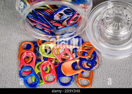 una vista ampia dall'alto verso il basso di un vaso di multi colorato può tirare le linguette che si posano sul suo lato e alcuni sdraiato Foto Stock