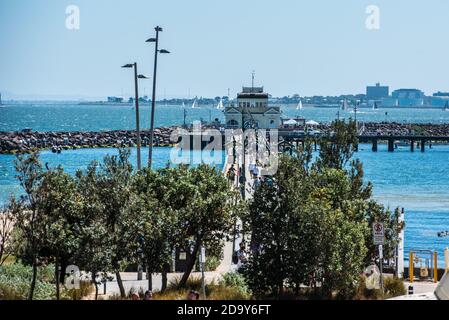 Una panoramica della baia e del St Kilda Pier a Melbourne. La gente ha sciamed la spiaggia popolare di St Kilda di Melbourne in una calda giornata di sole, la maggior parte evitando i requisiti del facemask e della distanza sociale. Foto Stock