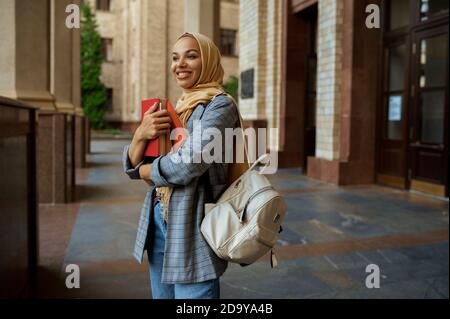 Studente arabo con libri all'ingresso dell'università Foto Stock